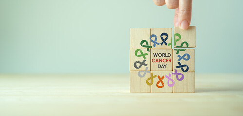 World cancer day (February 4). Colorful ribbons on wooden cube blocks background, cancer awareness, national cancer survivor day. Healthcare and medical concept.