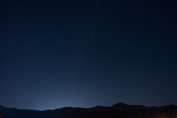 Many stars in the vast sky above the mountains