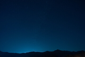 Many stars in the vast sky above the mountains
