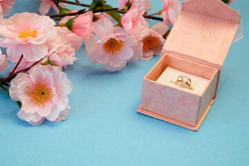 Obraz na płótnie Canvas wedding ring in a gift box and tree blossom flowers, wedding in spring time concept