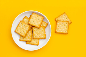 Dry cracker cookies on yellow background.