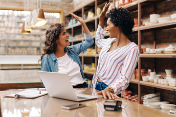 Two ceramists celebrating their success in their shop