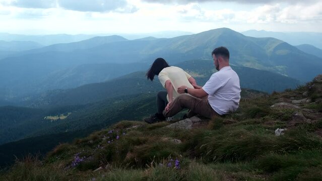 couple hikers resting on the top of Hoverla mount in Ukraine
