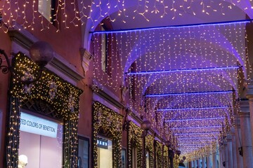 historic center of modena lit up at christmas with shop windows and shops decorated for christmas...