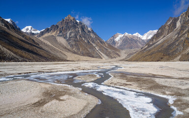 A high plateau with a frozen mountain river during the Kanchenjunga Base Camp Trek in Nepal. The...