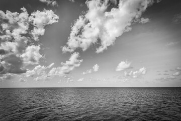 Dramatic sea view, monochrome  seascape, white clouds dark deep ocean bay. Coastline in black and...
