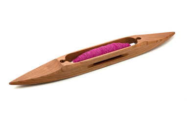 Isolated boat shuttle with pink or magenta yarn used in loom weaving. Wooden shuttle on white...