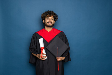education, graduation and people concept. happy Indian Male graduate student in mortarboard and bachelor gown