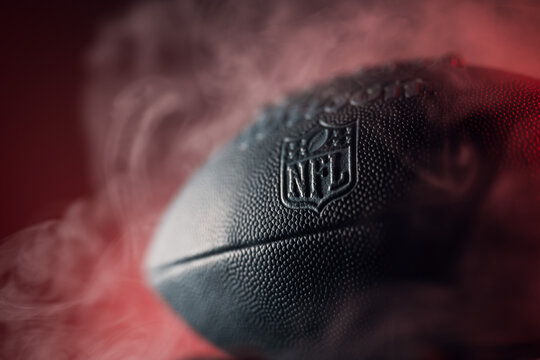 A football in epic light situation with the logo of the official brand "NFL National Football League" as symbol for the upcoming LVII Super Bowl