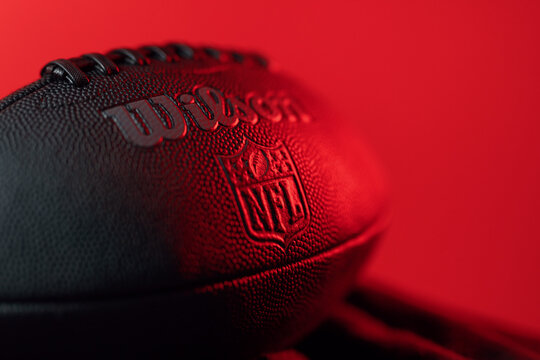 A football in epic light situation with the logo of the official brand "NFL National Football League" as symbol for the upcoming LVII Super Bowl