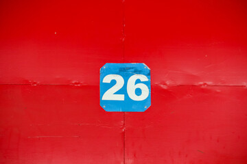 The number twenty six on a red background is at the gate