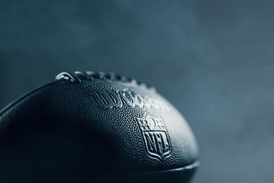 A football in epic light situation with the logo of the official brand "NFL National Football League" as symbol for the upcoming LVII Super Bowl