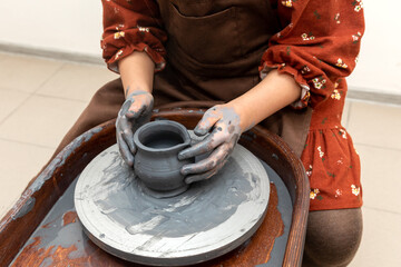 Pottery workshop. A little girl makes a vase of clay. Clay modeling. The concept of children's creativity.