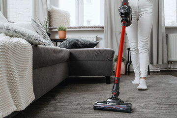 woman cleanup at home and vacuum rug on floor - obrazy, fototapety, plakaty