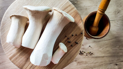 Royal oyster mushrooms or erings on a wooden board.