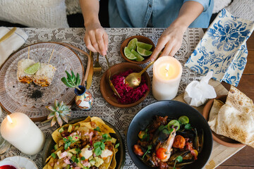 Horizontal shot of a woman's hand preparing a food in a bowl.