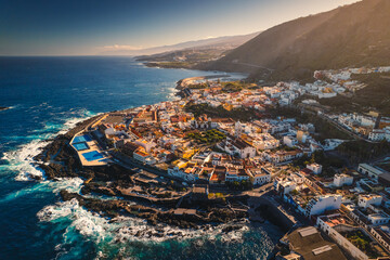 Aerial view of the city of Garachico and the surrounding coast. Sunny weather highlights the colors of the water.