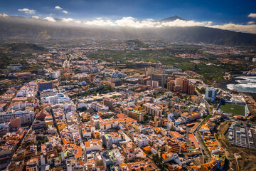 Aerial view of the city of Puerto De la Cruz and the surrounding coast. Sunny weather highlights the colors of the water.