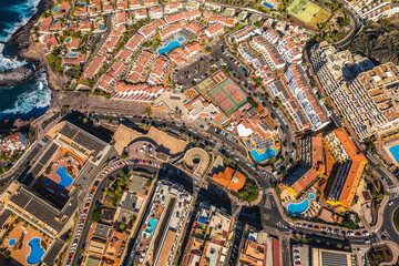 Fototapeta premium Aerial view of the city of Los Gigantes and the surrounding majestic cliffs. Sunny weather highlights the colors of the water.