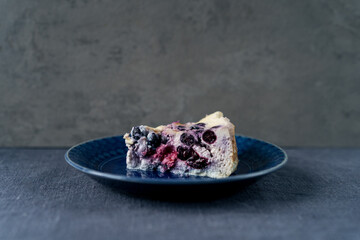 Сottage cheese casserole with berries on a blue plate with copy space