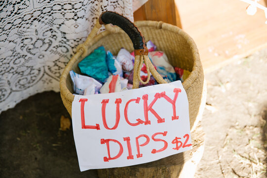 Close up shot of a basket with cloth inside and a signage that says lucky dips $2