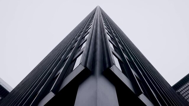 Looking up at tall dark monolithic high rise office tower in downtown Toronto Financial district