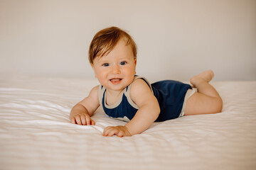 child playing, portrait of a baby in bed on a white background