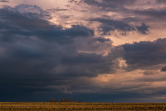 Blue violet red sunset sky background with evening curly rolling clouds may use for sky replacement