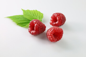 raspberries on a white background, maliny - obrazy, fototapety, plakaty