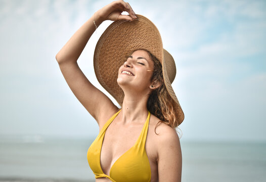 Young Woman Breathes Fresh Air At The Sea