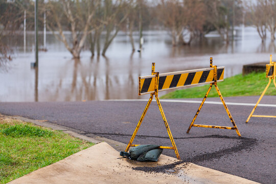 Signs blocking off road that is underwater during flood natural disaster