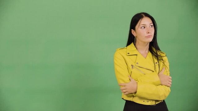 A young beautiful Caucasian woman thinks about something - green screen studio