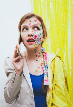 Woman with stickers on face talking through smart phone