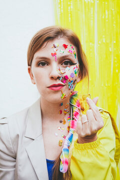 Woman with stickers on face gesturing heart shape