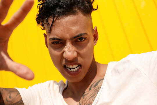 Angry young man gesturing on sunny day