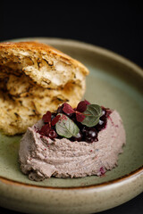Turkey pate with pine nuts, warm ciabatta isolated on black background.