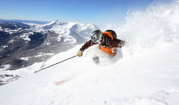 A skier makes a turn in deep powder.