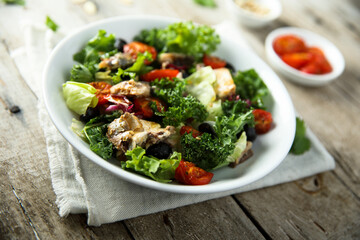 Healthy green salad with roasted tomatoes and fish