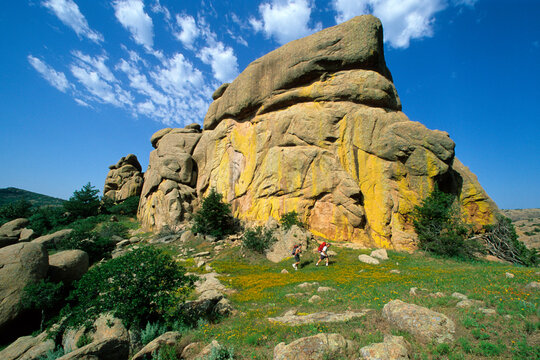 Hikers below colorful granite dome in the Wichita Wildlife Refuge near Lawton, OK.