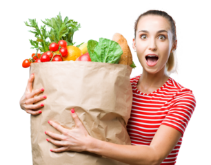 Cheerful young woman holding a grocery bag filled with vegetable