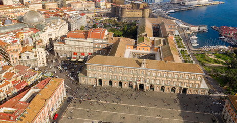 Fototapeta premium Aerial view of the Royal Palace of Naples, Italy. It was a royal seat for the kings of Naples and the Bourbons. It's located in Plebiscito square. In background the Maschio Angioino castle. 