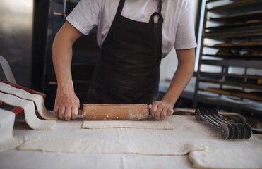 Close-up of baker preparing pastries in bakery.