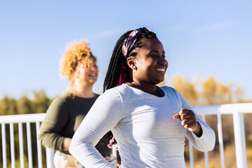 Two young plus size women jogging together.