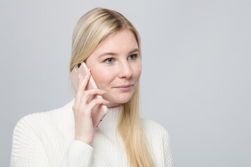 a blond woman is listening at her mobil phone