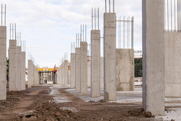 construction of an industrial building site with a line of concrete columns and reinforcing steel 