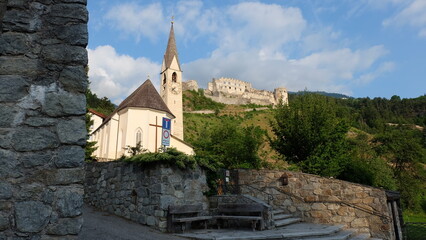 Fototapeta na wymiar Pfarrkirche mit Schloss Lichtenberg im Hintergrund Castello Di Montechiaro Südtirol