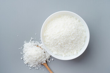 Close up of white soy wax in the bowl for candle making on gray background