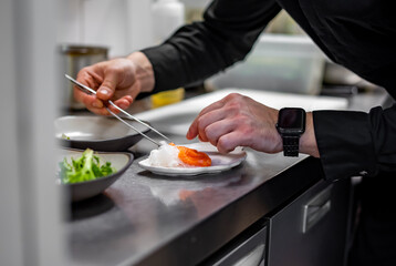 chef cooking slice salmon fish and shrimp with salad on kitchen