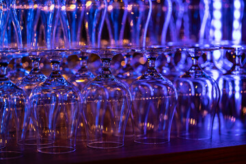 Clear rum glasses in the night bar glowing with neon colors