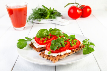 Crispbread with curd cheese, tomatoes, green onions, arugula and basilica. Delicious and healthy breakfast